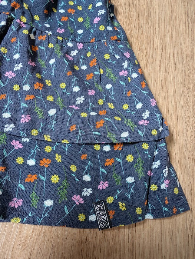 Close-up of the navy floral ruffle skirt showing the print and tiered hem