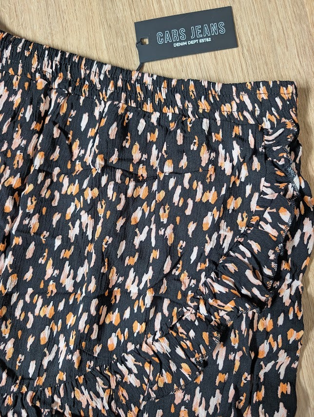 Close-up of the black ruffle skirt showing the pink and orange dot print