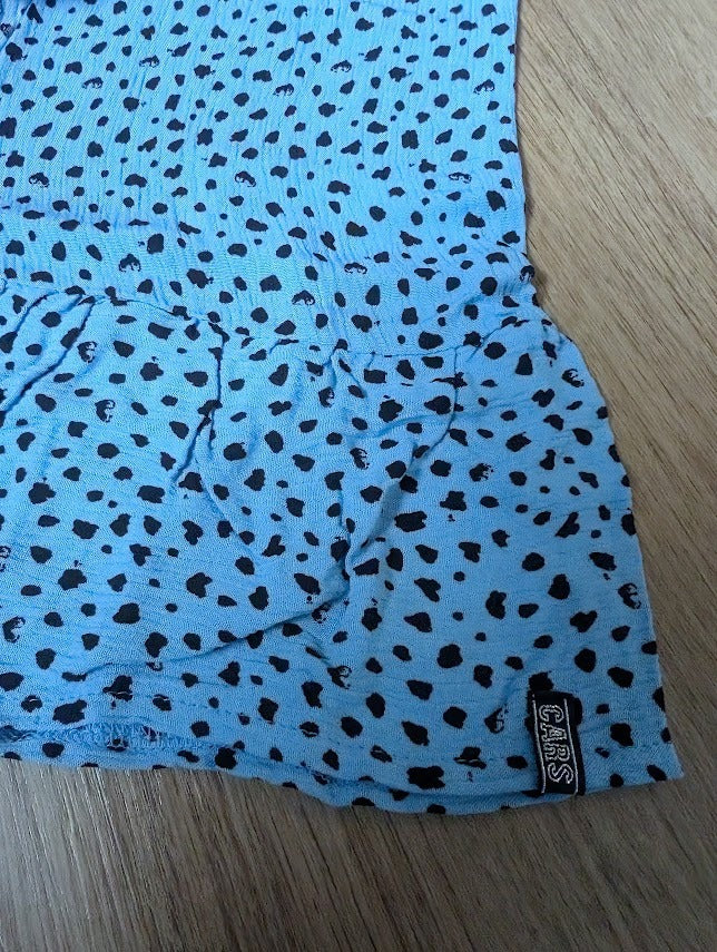 Close-up of the light blue skirt showing the black dot print and ruffle hem